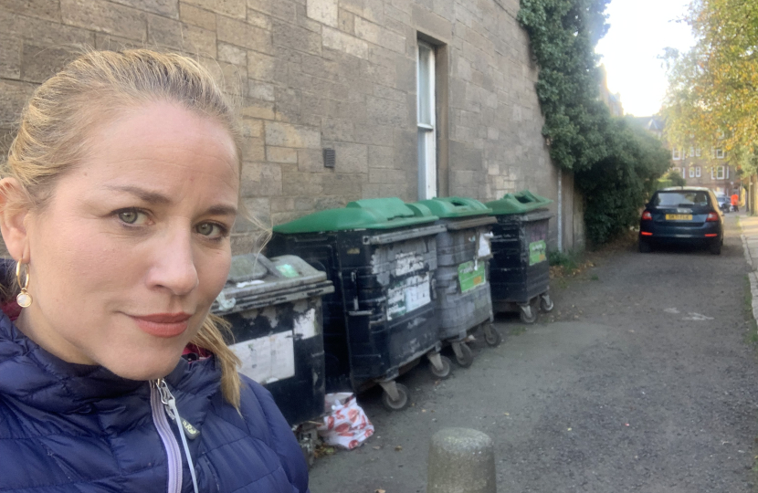 Cllr Marie Clair Munro is standing next to a bin hub.